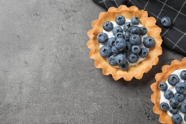 Delicious sweet pastry with berries on grey table, flat lay. Space for text - Foto, Bild