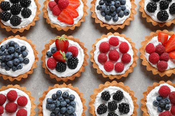 Different berry tarts on table, flat lay. Delicious pastries - Foto, immagini