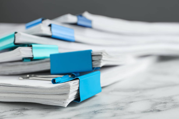 Stack of documents with binder clips on marble table, closeup - Foto, Bild