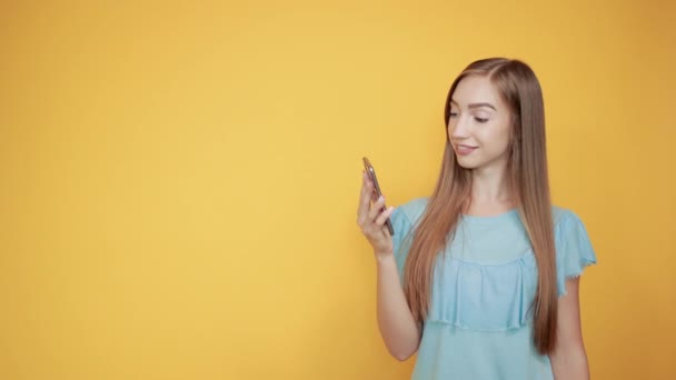 girl brunette in blue t-shirt over isolated orange background shows emotions - Felvétel, videó
