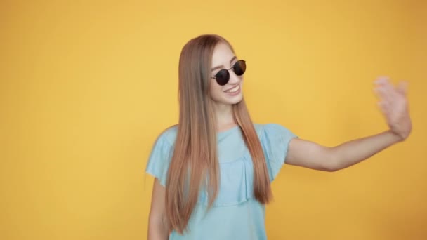 girl brunette in blue t-shirt over isolated orange background shows emotions - Materiał filmowy, wideo