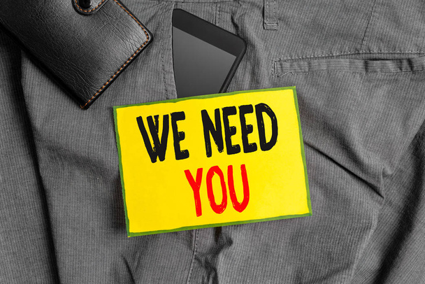 Conceptual hand writing showing We Need You. Business photo showcasing to fulfill the needs of the assignment duty or obligation Smartphone device inside trousers front pocket with wallet. - Photo, Image
