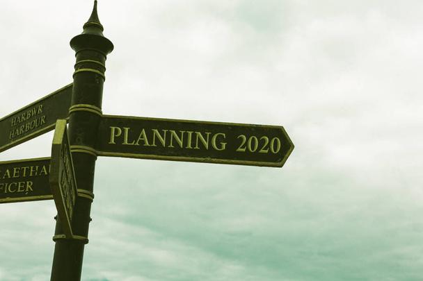 Text sign showing Planning 2020. Conceptual photo Begin with end in the Mind Positioning Long term Objectives Road sign on the crossroads with blue cloudy sky in the background. - Photo, Image