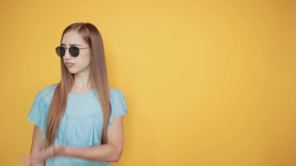 girl brunette in blue t-shirt over isolated orange background shows emotions - Video, Çekim