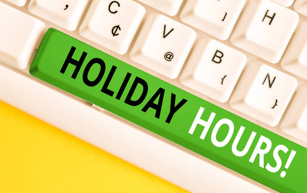 Word pisanie tekstu Holiday Hours. Koncepcja biznesowa dla pracy w nadgodzinach dla pracowników w ramach elastycznych harmonogramów pracy biała klawiatura PC z pustym papierem notatki powyżej białego tła klucza kopii miejsca. - Zdjęcie, obraz