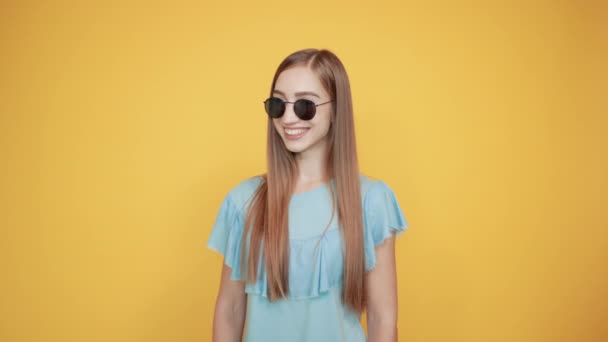 girl brunette in blue t-shirt over isolated orange background shows emotions - Кадри, відео