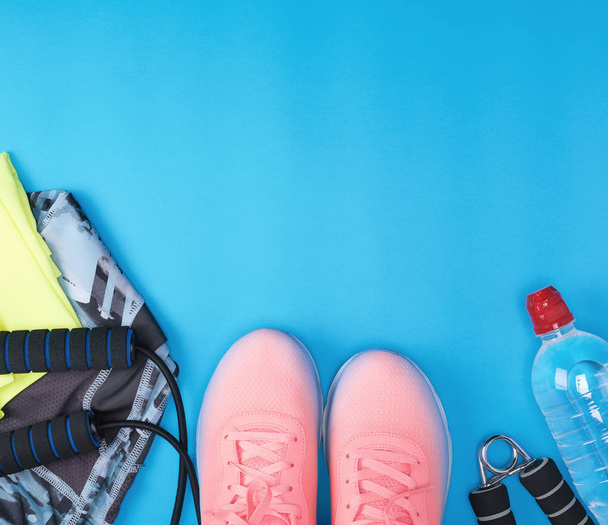 sport textiel schoenen en andere items voor fitness op een blauwe backgr - Foto, afbeelding