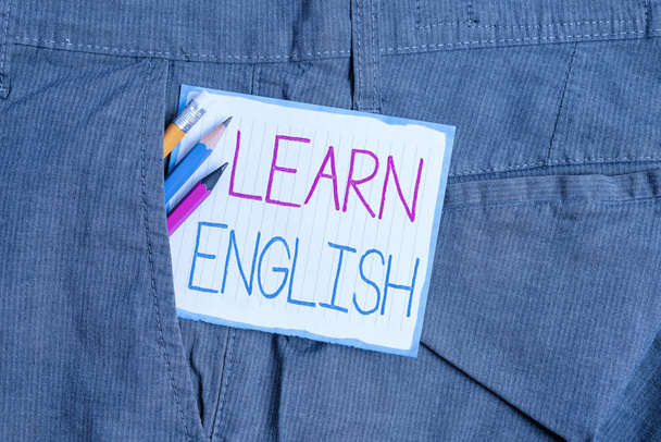 手書きテキスト英語を学びます。概念は、ユニバーサル言語の簡単なコミュニケーションと理解書き込み機器と男性の仕事のズボンのポケット内の白いノート紙を意味します. - 写真・画像