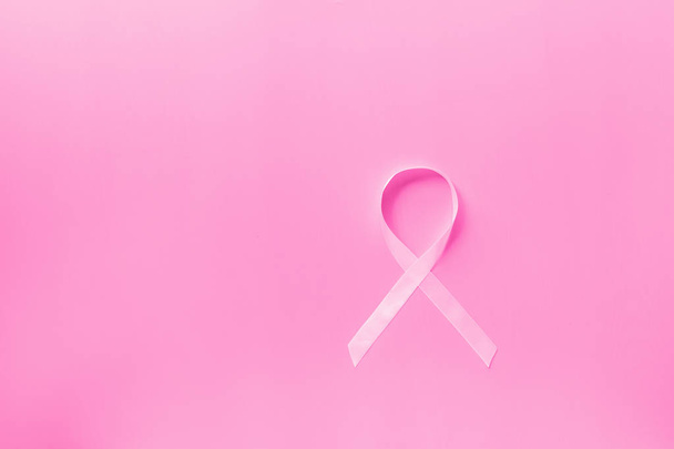 Słodki różowy kształt wstążki na różowe tło dla raka piersi symbol świadomości promować w październiku kampanii miesiąc. Płaski lay z przestrzenią kopiowania, widok z góry, makieta, narzut, szablon. Koncepcja opieki zdrowotnej - Zdjęcie, obraz