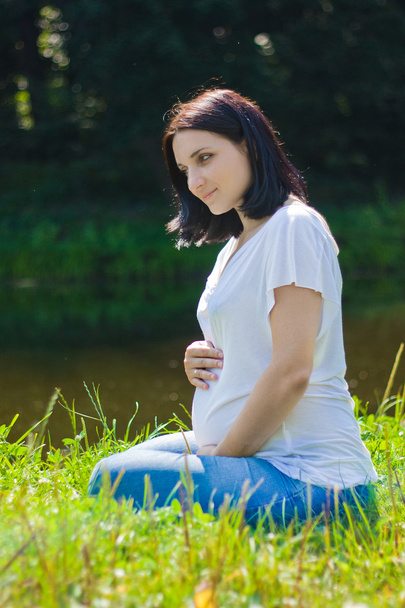 Pregnant woman sits - Foto, afbeelding