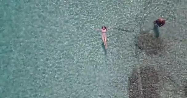 Przyjaciółka i chłopak mający zabawa w The morze aerial wideo - Materiał filmowy, wideo