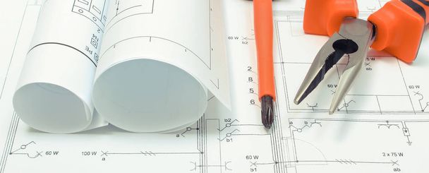 Diagramas elétricos e ferramentas de trabalho no desenho de construção de casa. Construção de casa conceito
 - Foto, Imagem