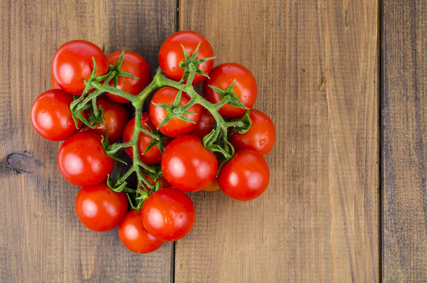 Punaisia pieniä pyöreitä tomaatteja puupohjalla
.  - Valokuva, kuva