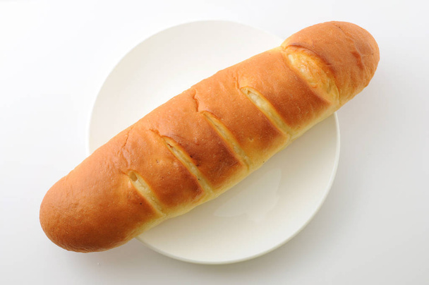 longo pão manteiga closeup isolado na placa no fundo branco
 - Foto, Imagem