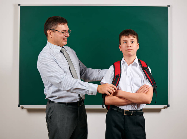 Portrait of a teacher and schoolboy playing at blackboard background - back to school and education concept - Photo, Image