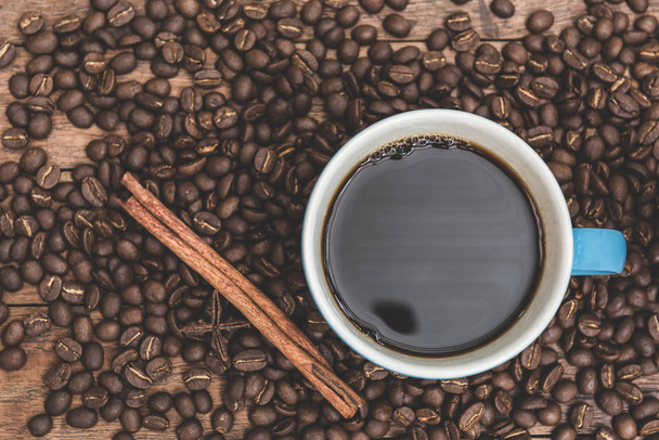 Modrý kávový pohár, skořicové, badyákové a kávové fazole na dřevěné b - Fotografie, Obrázek