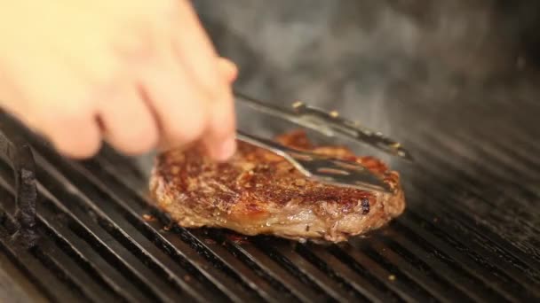 ο σεφ γυρίζει το καπνιστό βοδινό φιλέτο στη σχάρα. κοντινό - Πλάνα, βίντεο