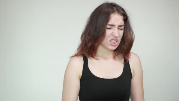 όμορφο κορίτσι σε μαύρο αμάνικη μπλούζα πάνω από απομονωμένο λευκό φόντο δείχνει τα συναισθήματα - Πλάνα, βίντεο