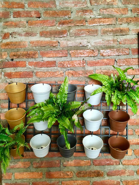 Petit pot de fleurs suspendu au mur de briques, idées décoration de jardin intérieur
  - Photo, image