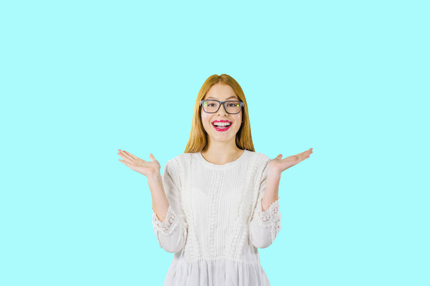 Portrait of a young beautiful red-haired girl in glasses, who emotionally and with hand gestures shows positive emotions and laughter, photo on an isolated background - Foto, immagini