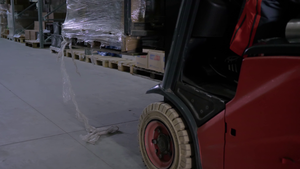 řidič vysokozdvižného vozíku, který vyzvedne krabice se zbožím ve velkém skladu - Záběry, video