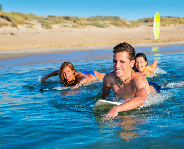 Teenager surfer boys and girls swimming ove surfboard - Foto, imagen