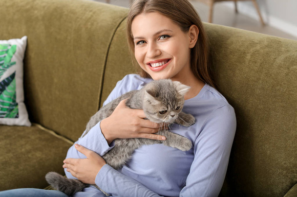 Красивая молодая женщина с милым котом дома - Фото, изображение