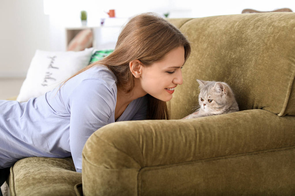 Beautiful young woman with cute cat at home - Фото, зображення