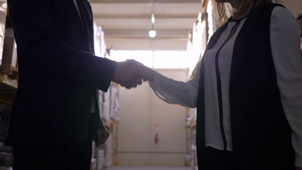 stretta di mano in controluce tra uomo d'affari e donna d'affari a magazzino
 - Filmati, video