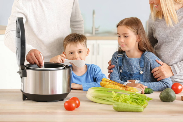 Happy family using modern multi cooker in kitchen - 写真・画像