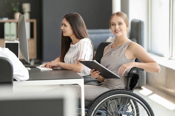 Jeune femme handicapée avec des collègues travaillant au bureau
 - Photo, image
