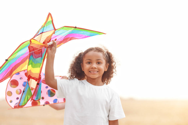 Little African-American girl flying kite outdoors - Фото, изображение