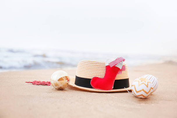 Шляпа с рождественским декором на берегу моря. Рождественские каникулы
 - Фото, изображение