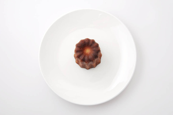 canele de Bordeaux french pastry on plate isolated on white background - Photo, Image