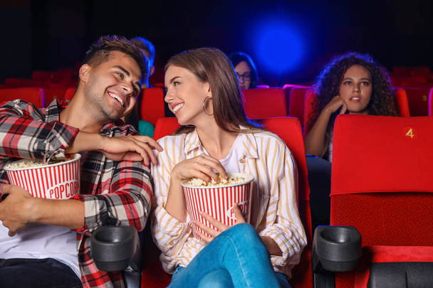 Couple with popcorn watching movie in cinema - Photo, Image