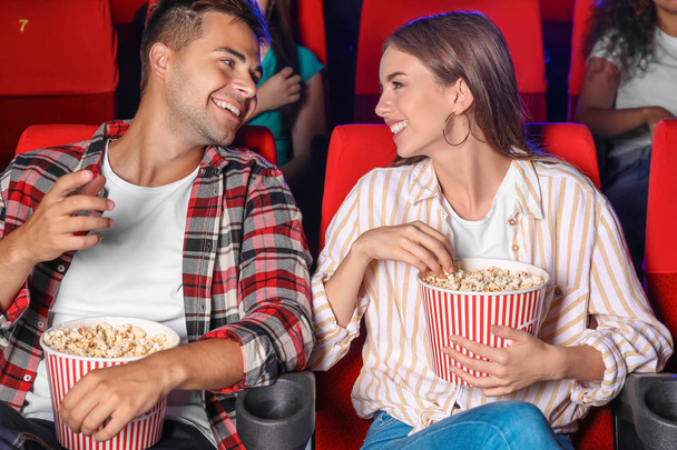 Couple with popcorn watching movie in cinema - Photo, Image
