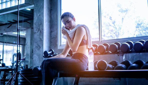 Female athlete resting, Young Woman Looking Away While Wiping Face In Gym - Foto, Imagem