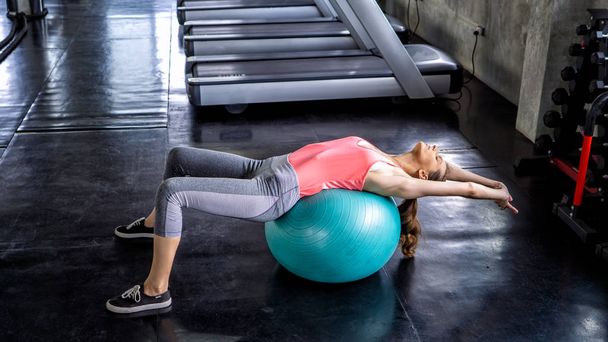 Women doing yoga body lying on ball in gym - Valokuva, kuva
