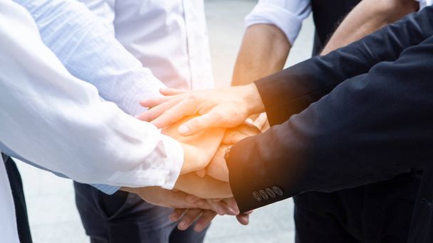az üzletemberek kéz a kézben ököllel osztoznak az egység és a csapatmunka koncepcióján. - Fotó, kép