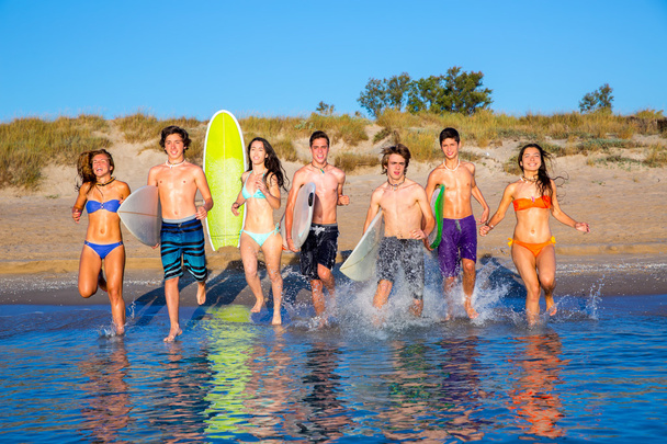 Группа юных серферов, бегущих по пляжу
 - Фото, изображение