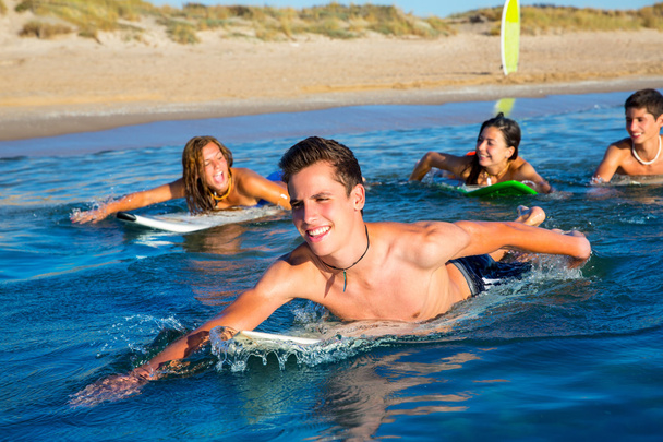 Teenager surfer boys and girls swimming ove surfboard - Foto, afbeelding