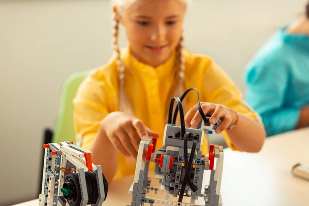 Κορίτσι οικοδόμηση ένα ρομπότ στο μάθημα της επιστήμης. - Φωτογραφία, εικόνα