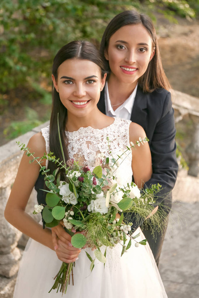 Hermosa pareja de lesbianas en su boda al aire libre
 - Foto, imagen