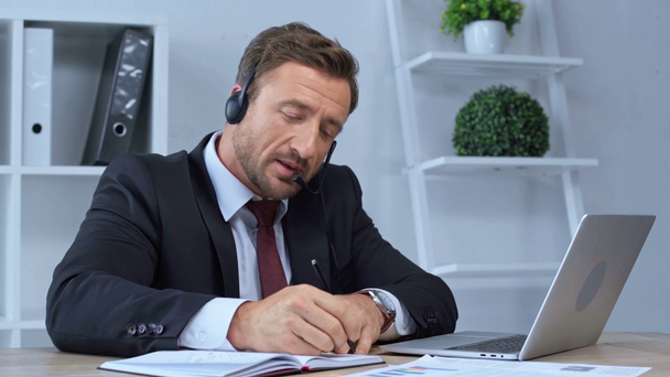 Τελεστής κέντρου κλήσεων στα ακουστικά που εργάζονται στο γραφείο - Πλάνα, βίντεο
