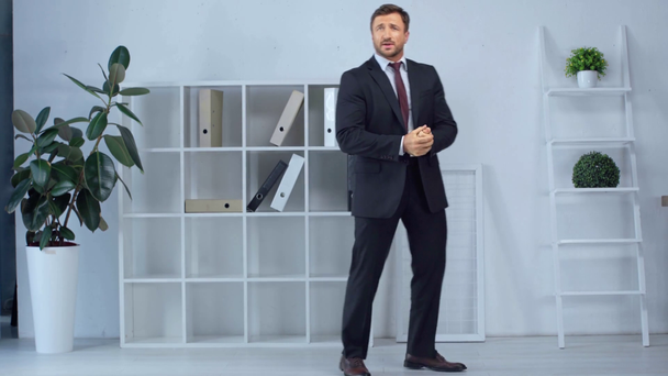 Reifer Geschäftsmann im Anzug boxt in modernem Büro - Filmmaterial, Video