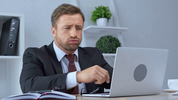 tired mature businessman in glasses using laptop - Metraje, vídeo