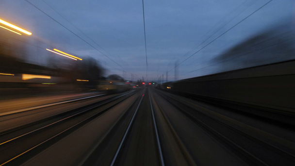 Zug fährt nahe bewohntem Ort an Laternen und Stromleitungen vorbei - Filmmaterial, Video
