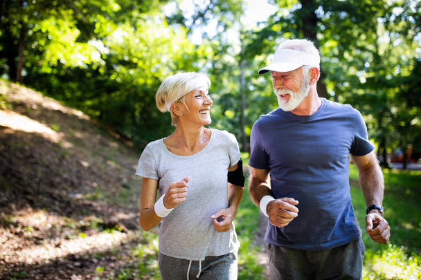 Beautiful sporty senior couple staying fit with running and jogging - 写真・画像