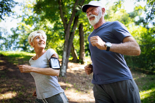 Beautiful sporty senior couple staying fit with running and jogging - Фото, зображення