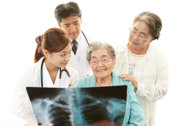Asya sağlık personeli ile yaşlı kadın gülümsüyor - Foto, afbeelding